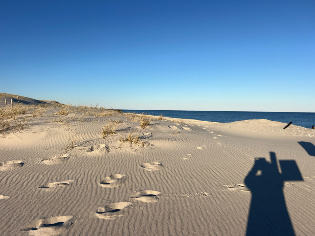 a person's shadow on a sandy beach (MyCoast AI)