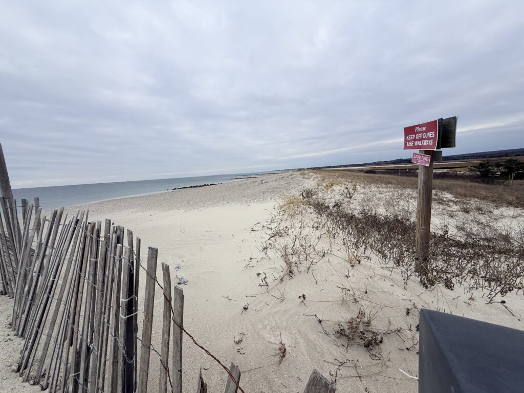 a beach with a fence and a sign (MyCoast AI)