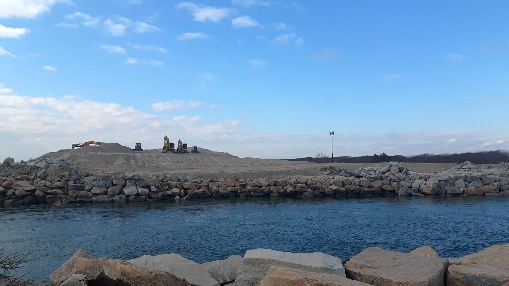 a body of water with rocks and a hill in the background (MyCoast AI)