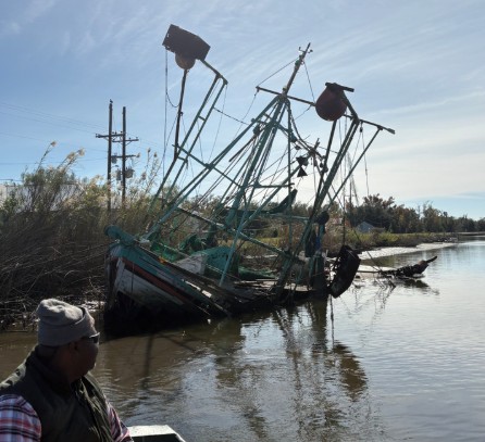 a man standing next to a boat (MyCoast AI)