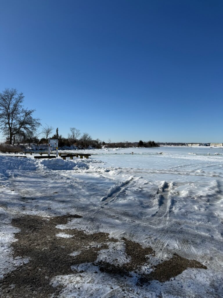 a frozen lake with trees and blue sky (MyCoast AI)