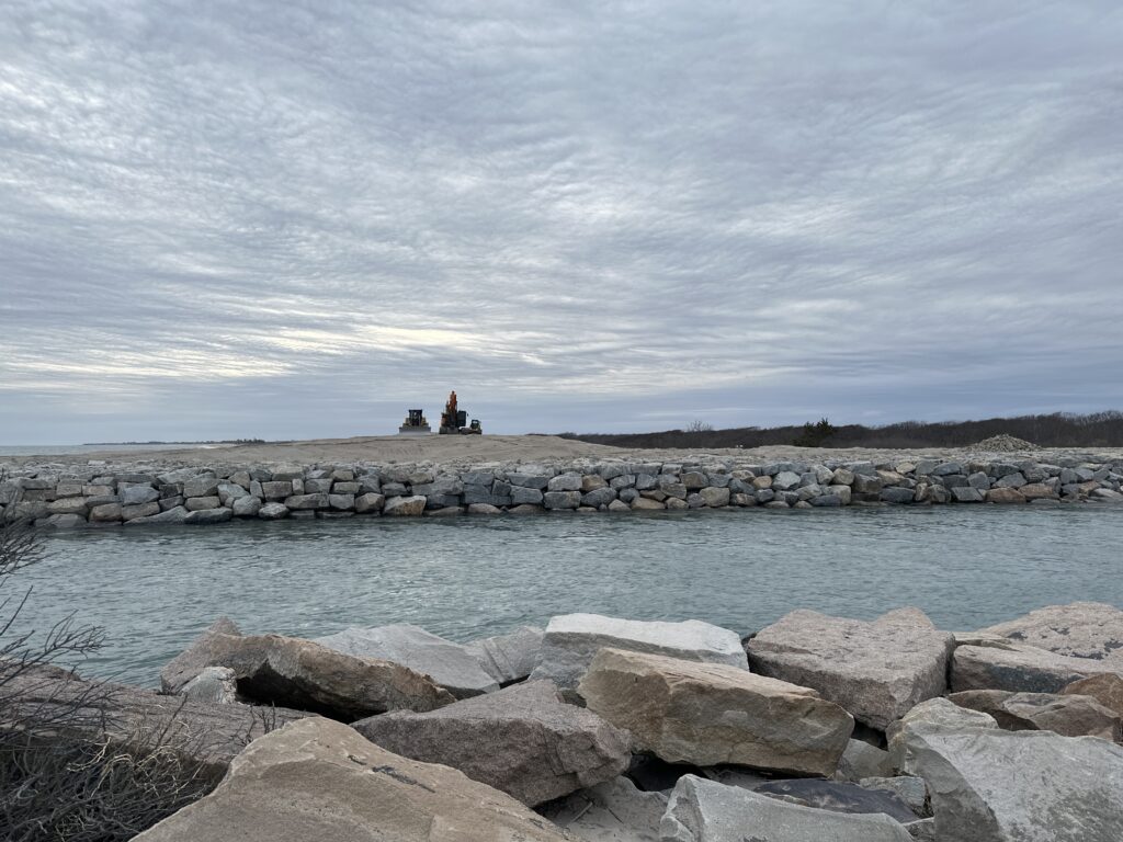a couple people sitting on a rock by a body of water (MyCoast AI)
