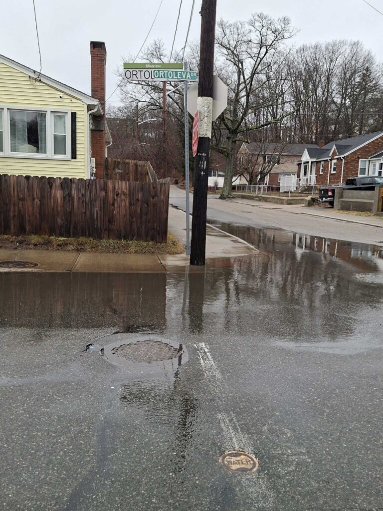 a flooded street with a street sign (MyCoast AI)