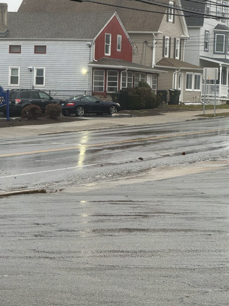 a street with cars parked on the side and houses in the background (MyCoast AI)