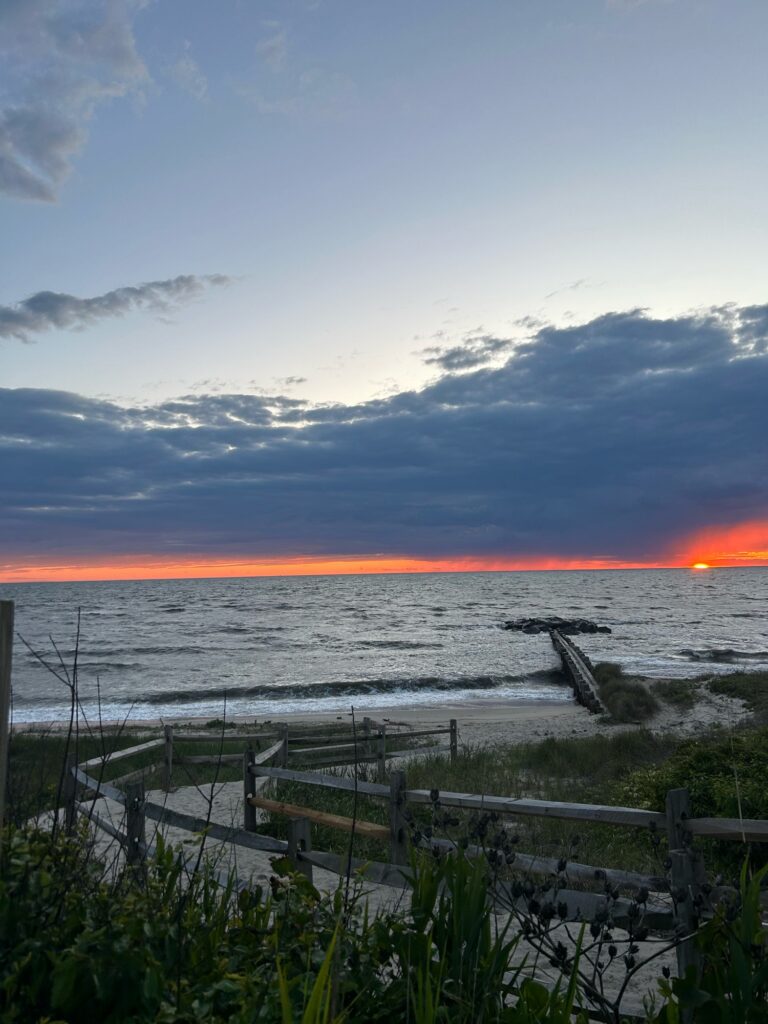 a beach with a fence and a sunset (MyCoast AI)