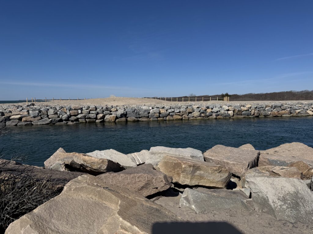 a body of water with rocks and a bridge in the background (MyCoast AI)