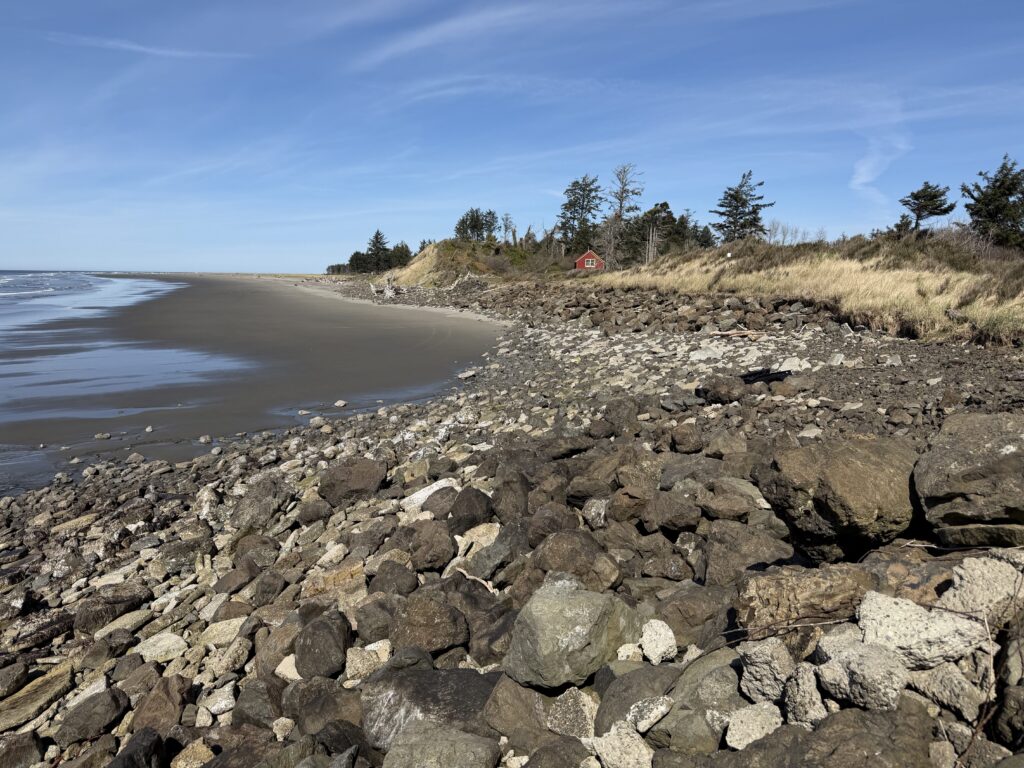 a rocky beach with a red house (MyCoast AI)