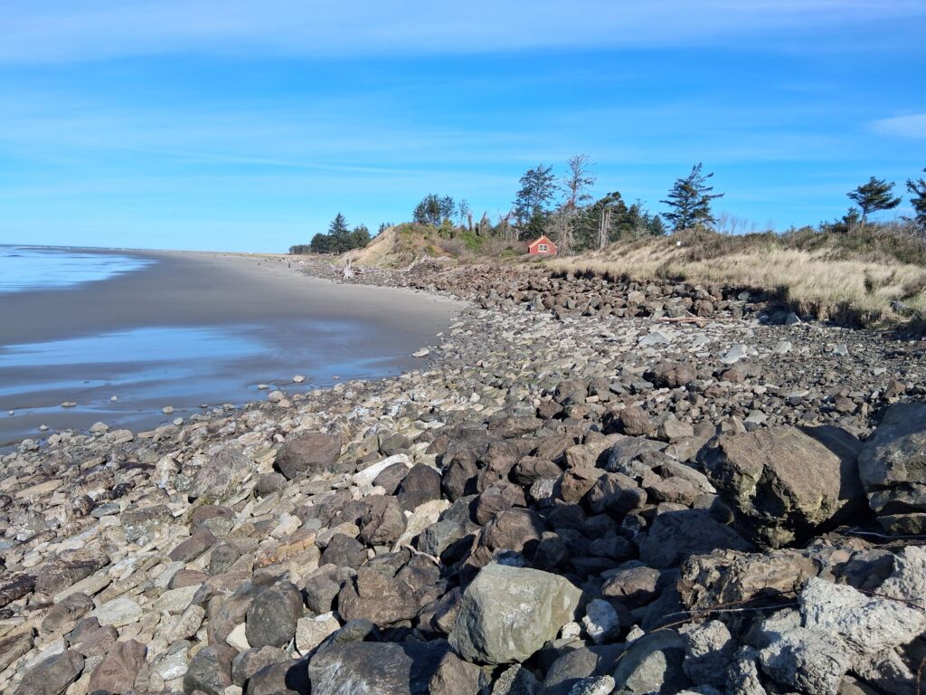 a rocky beach with a small house (MyCoast AI)