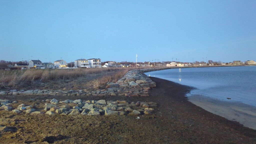a rocky beach with houses in the background (MyCoast AI)