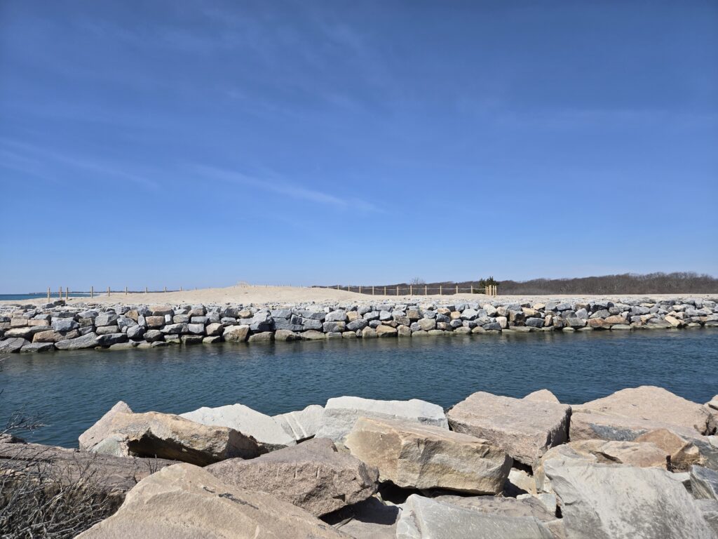 a body of water with rocks and a building in the background (MyCoast AI)