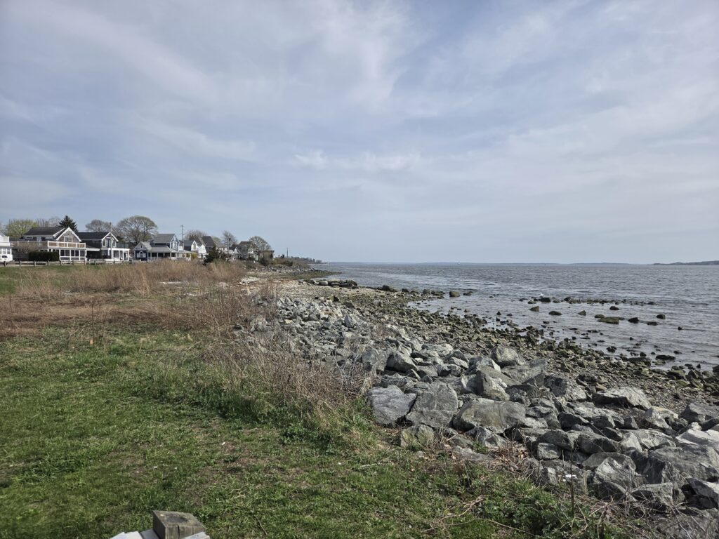 a rocky beach with houses and water (MyCoast AI)