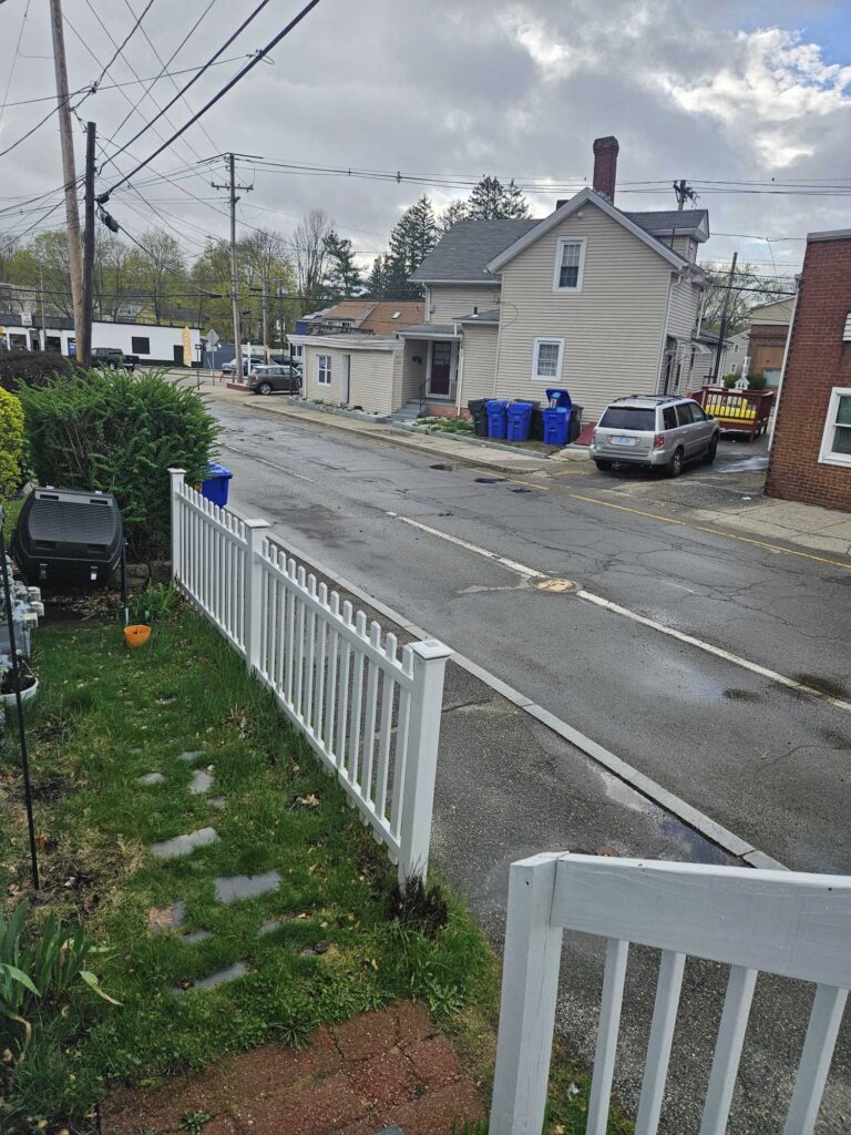 a road with a white fence and a white picket fence and houses (MyCoast AI)