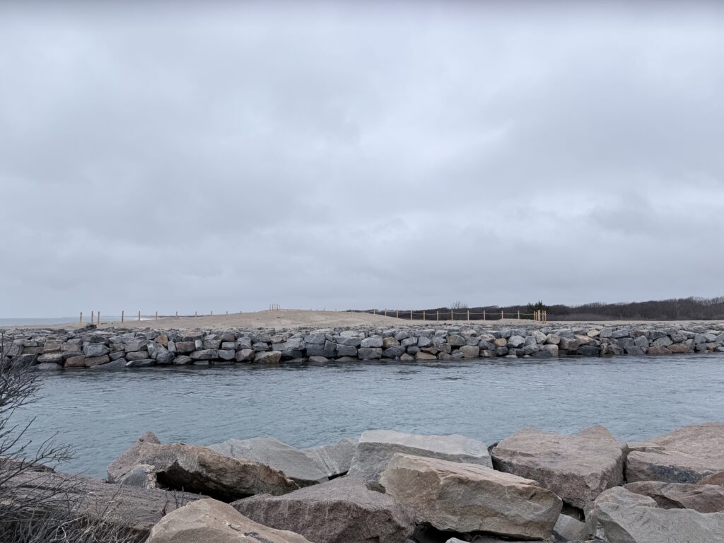 a body of water with rocks and a bridge in the background (MyCoast AI)