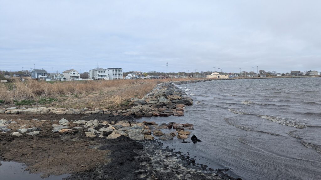 a rocky beach with houses in the background (MyCoast AI)