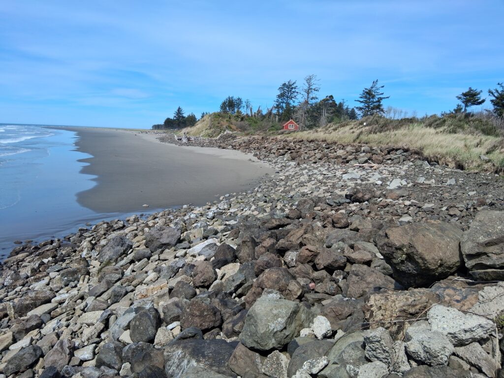 a rocky beach with a red house (MyCoast AI)