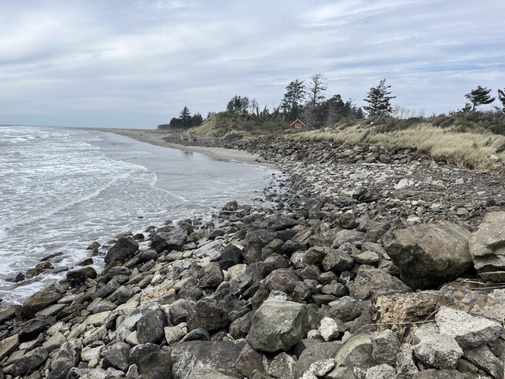 a rocky beach with a house in the distance (MyCoast AI)