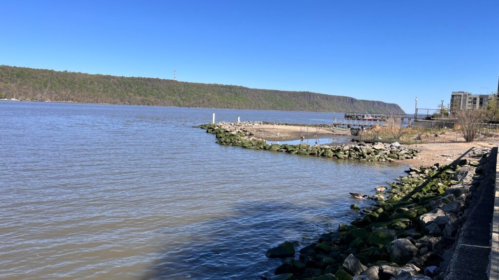 a body of water with rocks and a hill in the background (MyCoast AI)
