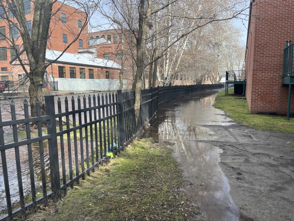 a canal with a fence and buildings (MyCoast AI)