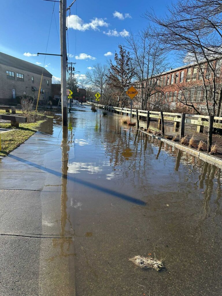 a flooded street with a yellow sign (MyCoast AI)
