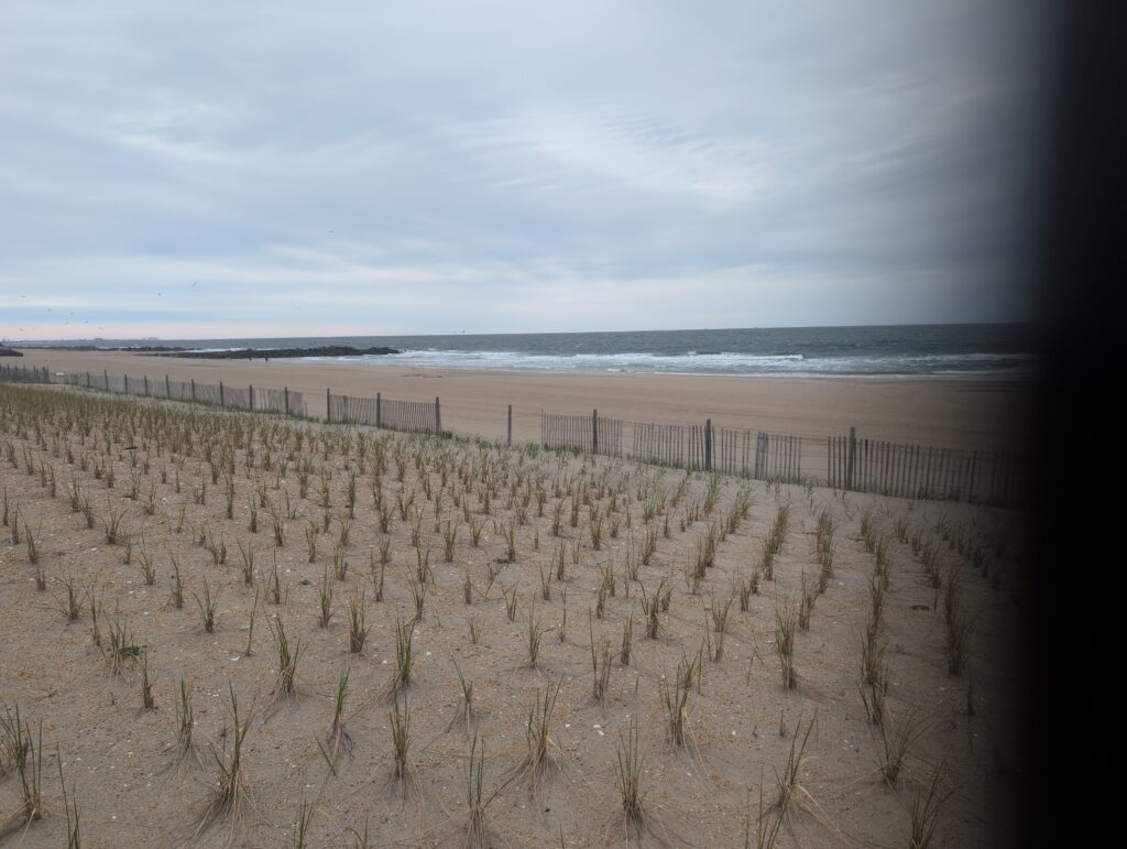 a beach with a fence and a cloudy sky (MyCoast AI)