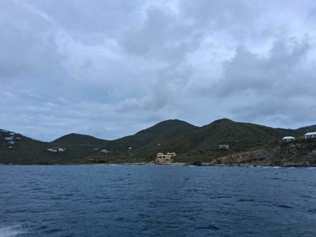 a body of water with a hill and buildings in the background (MyCoast AI)