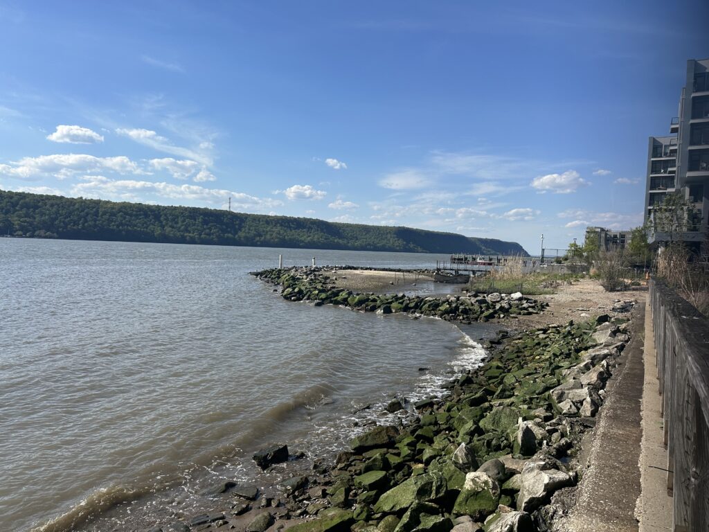 a body of water with rocks and a building along it (MyCoast AI)